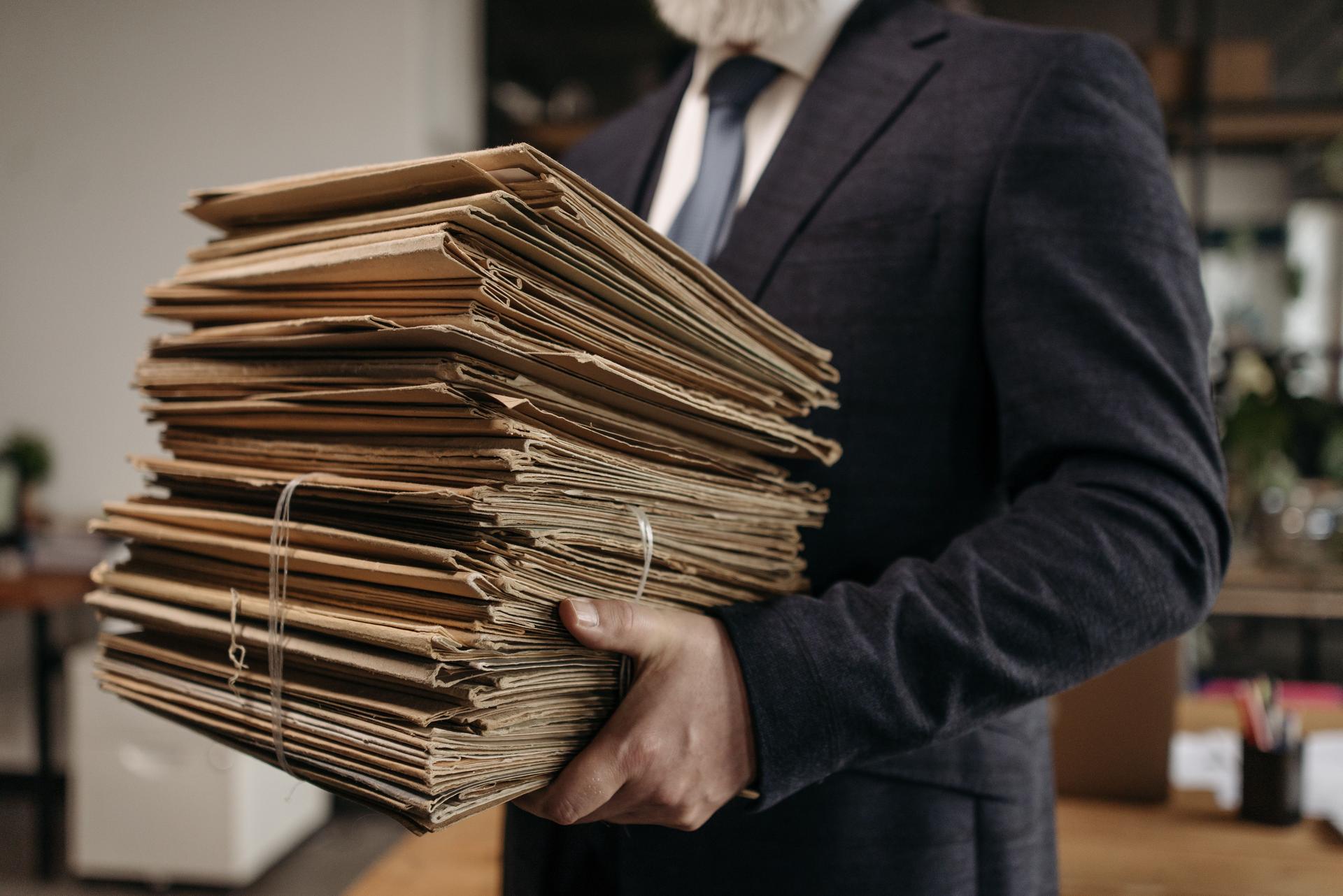 An advocate carrying a bundle of tied case files